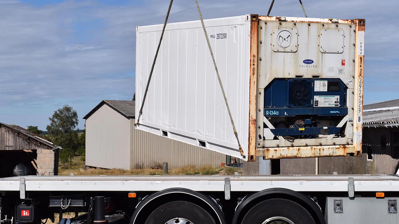 Livraison et déchargement par bras de grue d'un container frigorifique